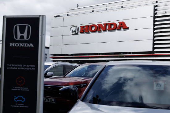 一家本田门店外景，建筑上醒目展示本田标志，前方停放多辆汽车。因北美电动汽车市场放缓，本田正取消部分车型的推出与研发。