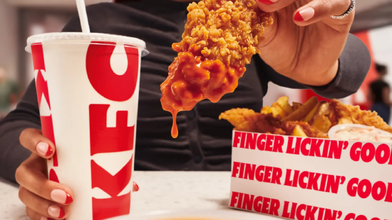 Le client tient un filet de poulet désossé avec une trempette et une boisson KFC, simulant un selfie pour s'enregistrer.