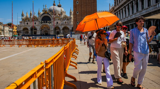 Los turistas sostienen paraguas y ventiladores para resistir la ola de calor extrema en la Piazza San Marco en Venecia, Italia, el 24 de junio de 2026. La masa de aire africana de alta presión está arraigada en la llanura del río Po en el norte de Italia. La temperatura local superó significativamente el promedio estacional, y la temperatura más alta alcanzó los 35 grados centígrados ese día.